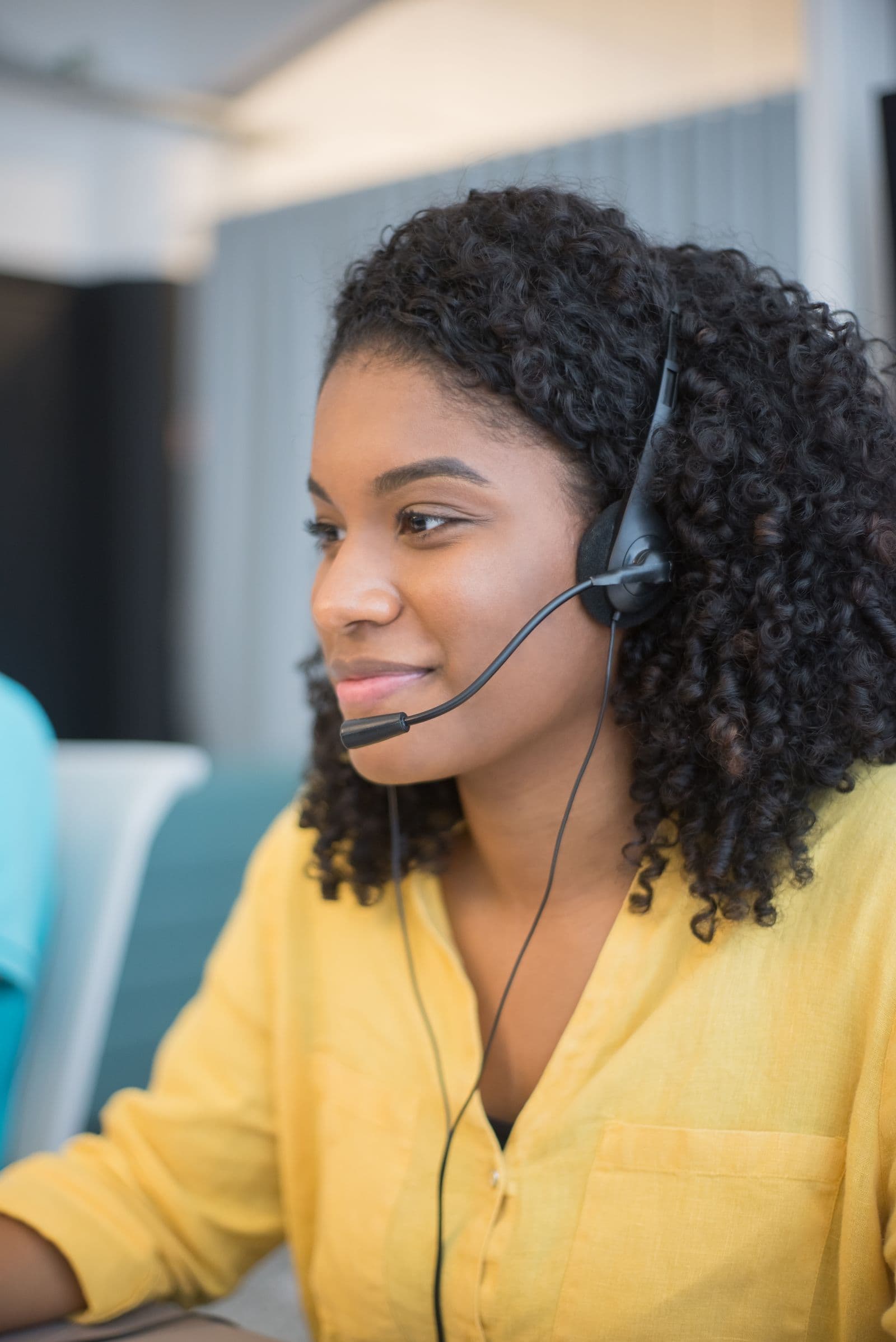 A smiling woman in a headset on a call